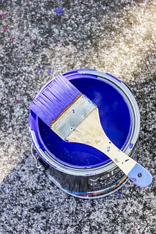 a paint can and paint brush to suggest painting the storage shed a pretty color