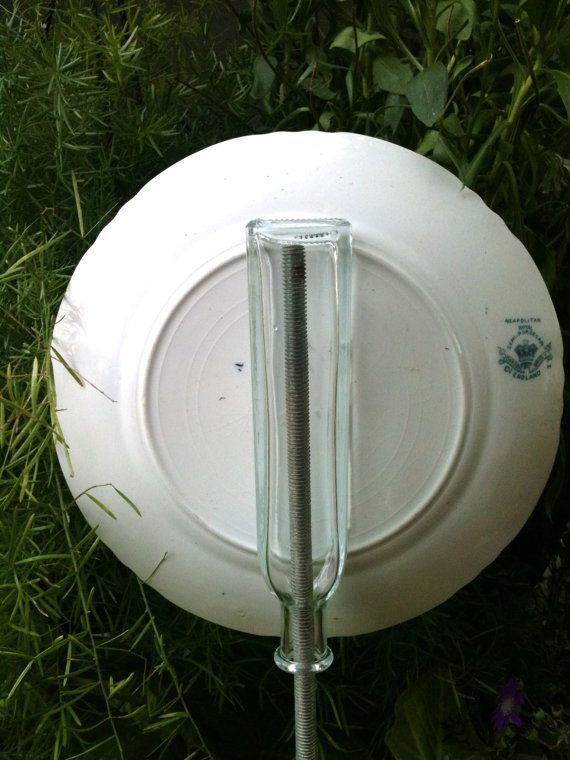 Dish flower showing one method to attach it to a stake. Clear glass bottle glued upside-down to plate. Slip the bottle over the top of a metal rod