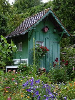 Garden sheds. This one is quite small, with steep pitched roof and little windows surrounded by wildflowers in bloom