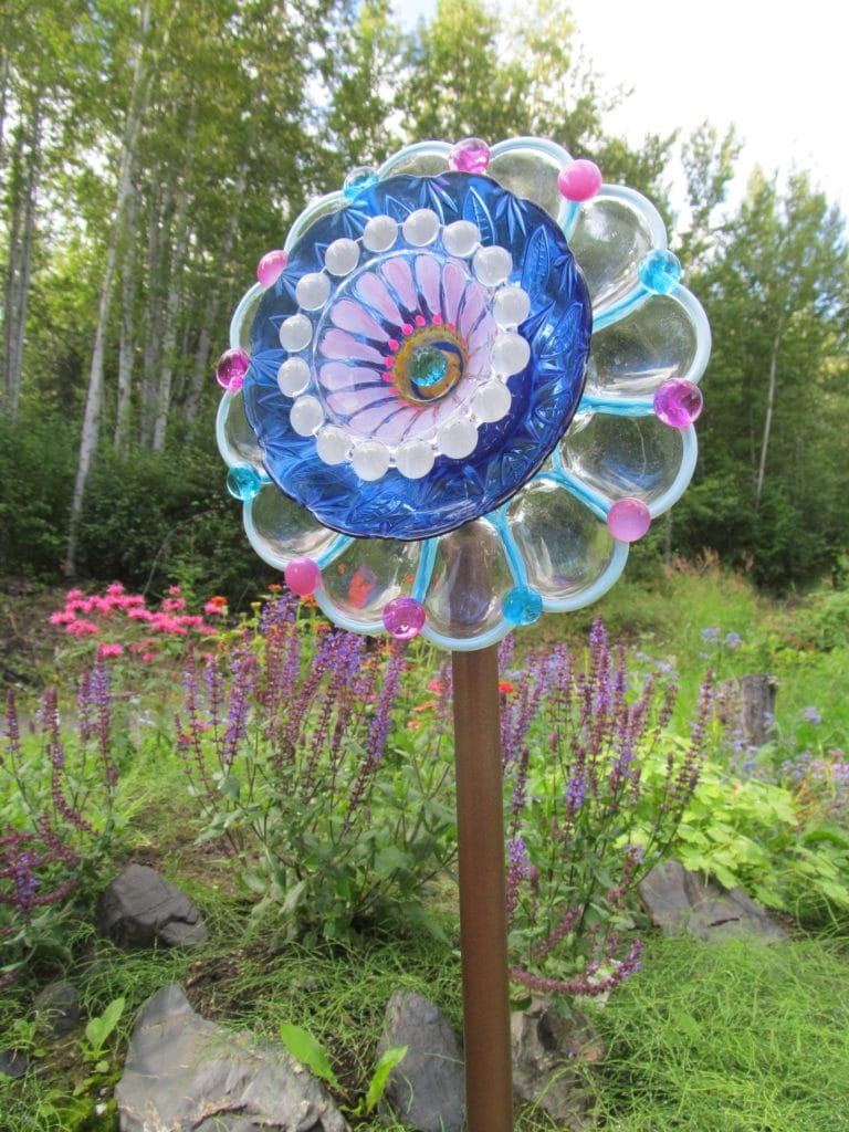 one of the artist's best dish flowers made with several different shaped glass dishes using bright blue and pink and lavender and white colors. 