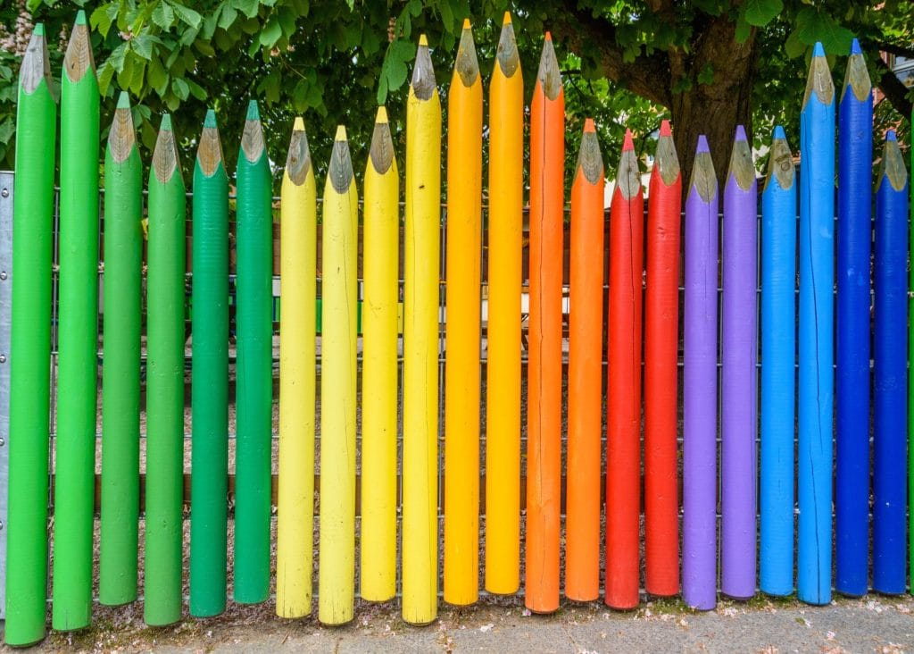 vertical parts of wooden fence shaped to look like colored pencils. 