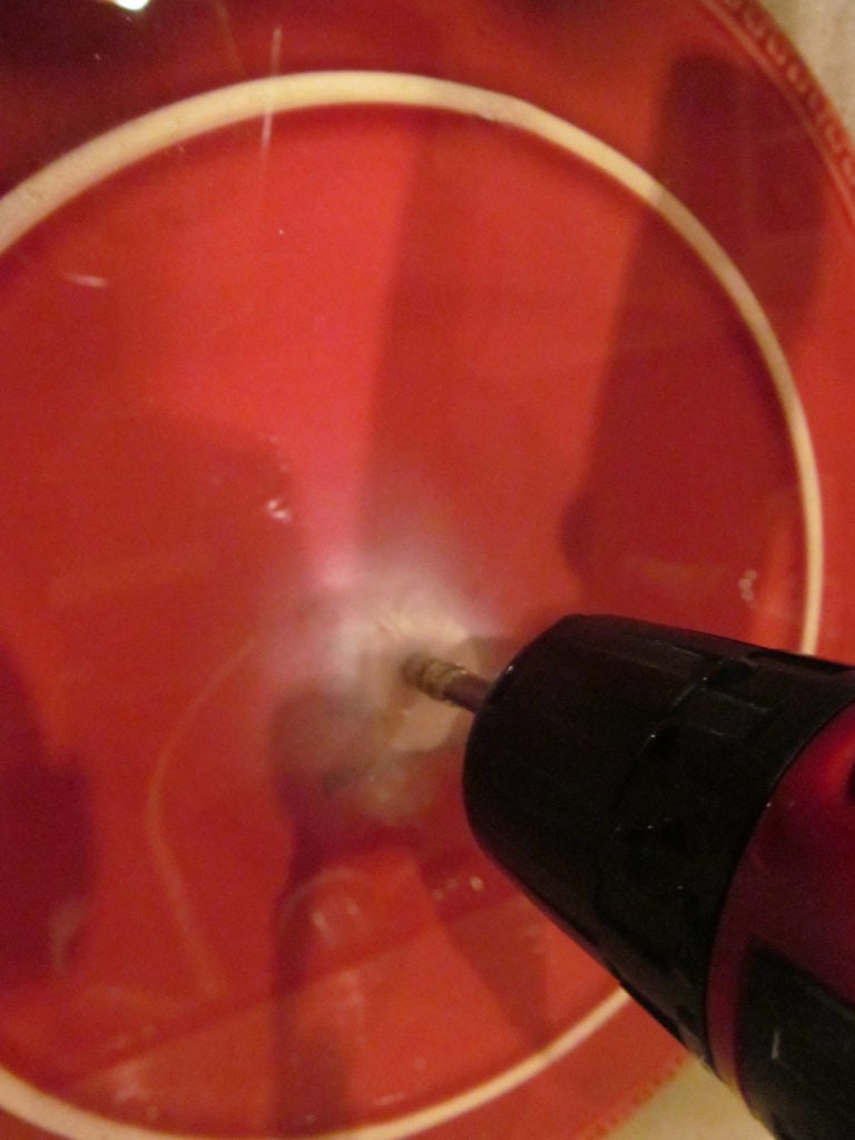 demonstration photo. Close up of a ceramic plate being drilled and fine dust-like residue from the impact area