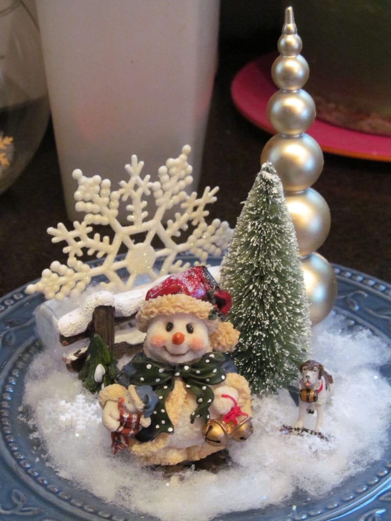 shows a winter scene created inside a snowman globe decoration