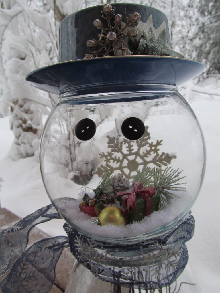 the headpiece of a Snowman Globe make with clean glass vase to show items inside. One-of-a-kind snowman crafts