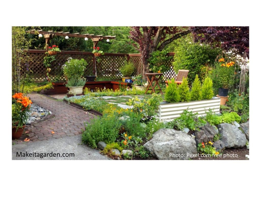 Woodland garden theme with small pine trees, small boulders and flowers planted around a patio
