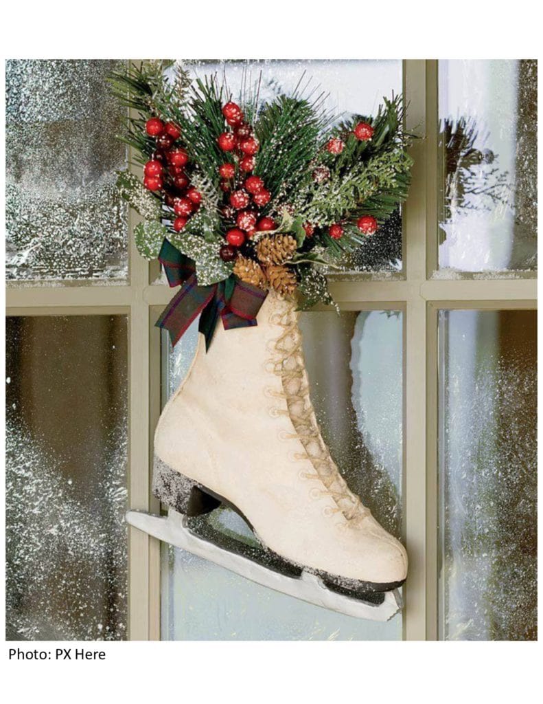 Ladies figure skate turned into a decoration by the front door. the ice skate is stuffed with Christmas greenery, fake cranberries and pine cones with a ribbon