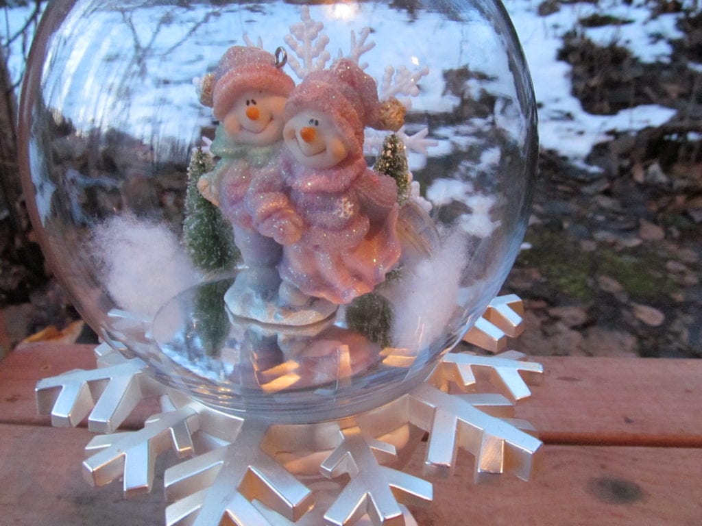 a glass globe with a bear couple ice skating. Demonstrates how to prevent a problem for glue and glass garden art