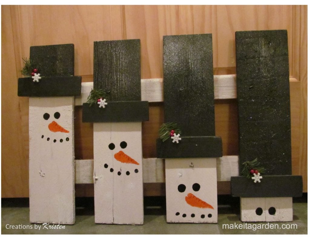 snowman pallet art photo of pallet painted to look like 4 individual snowmen with black hats