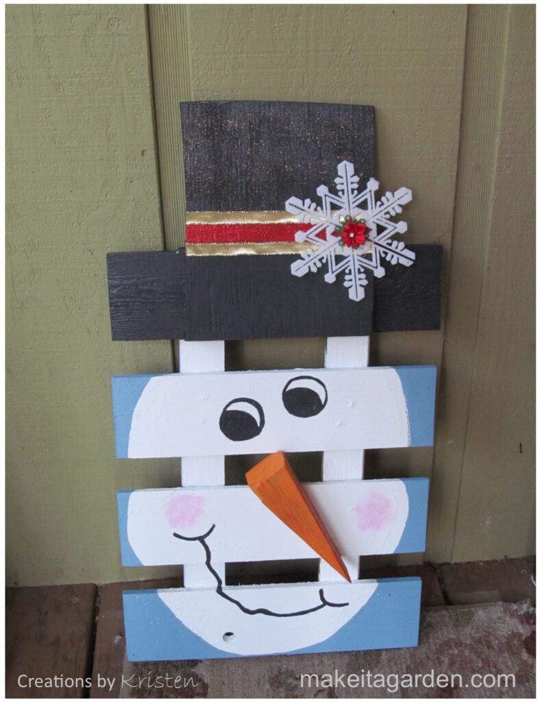 photo of the craft. A wood pallet painted with the face of a snowman