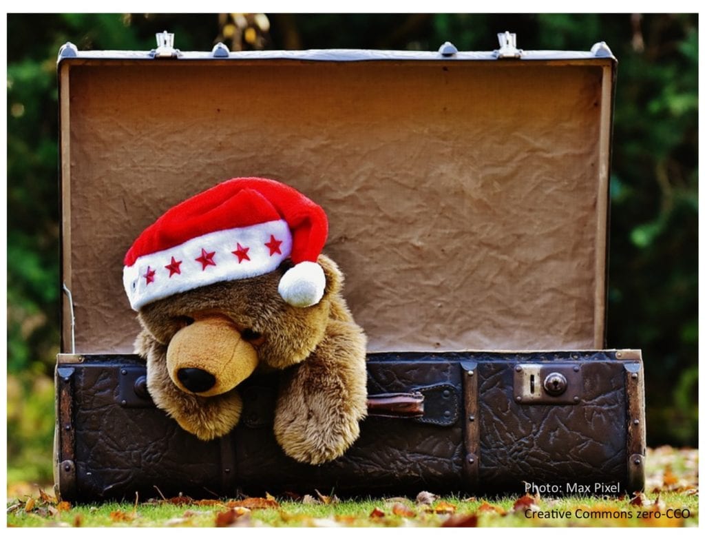 Teddy bear with Santa hat in an opened  vintage suitcase to make a cute little display