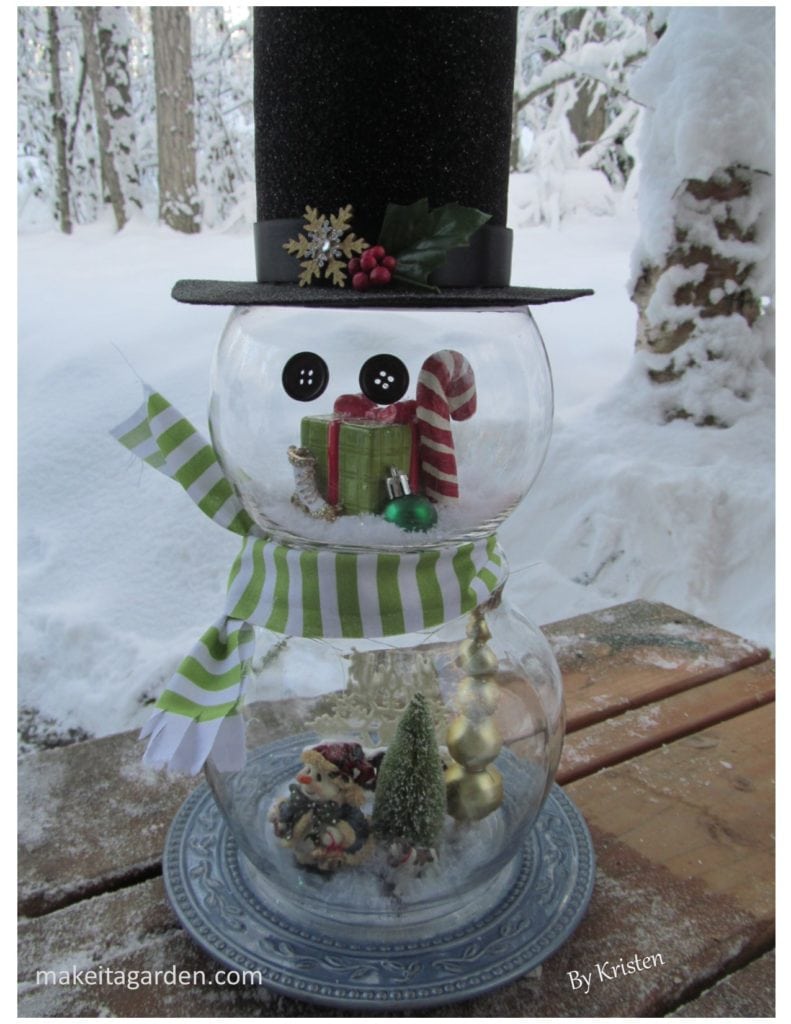Snowman craft decoration made with 2 small glass fishbowls with a tall stove pipe hat that was handmade