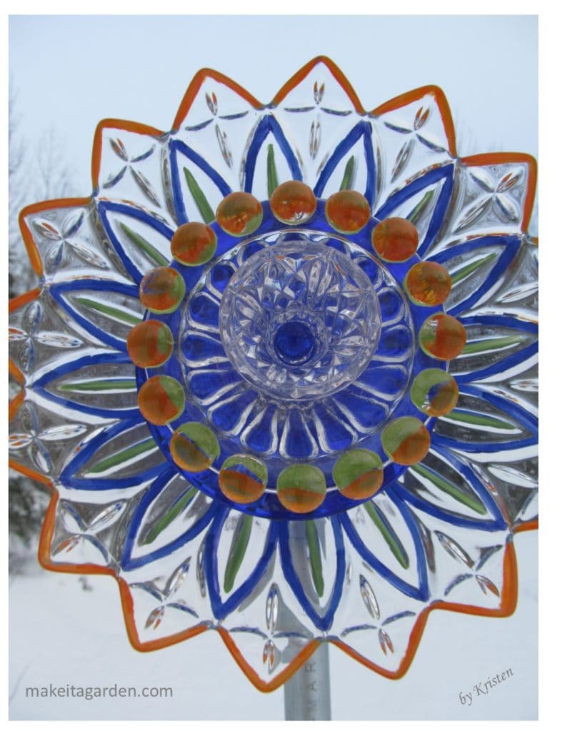 Frilly glass plate painted bright colors. It's called a "dish flower" garden art.