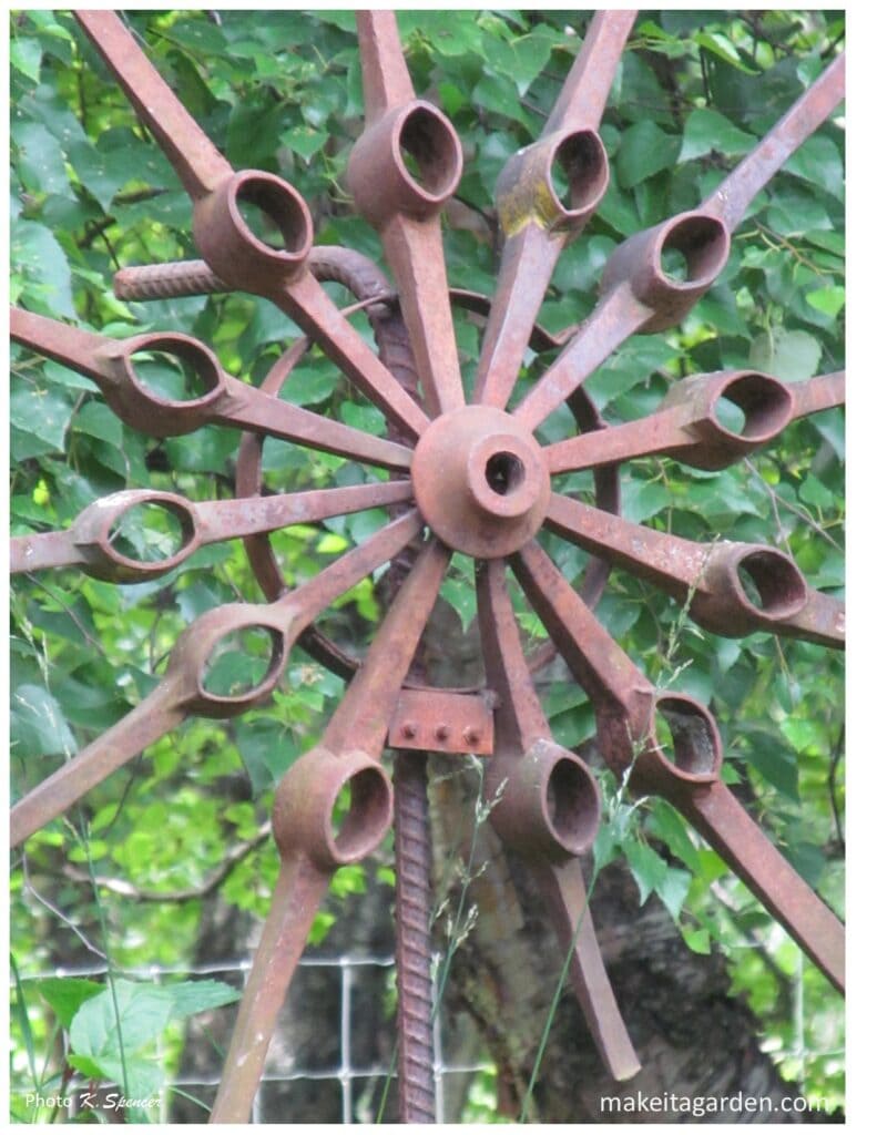 Close up of a large rusty metal flower sculpture made from axe heads. Imaginative sculptures make Palmer Garden