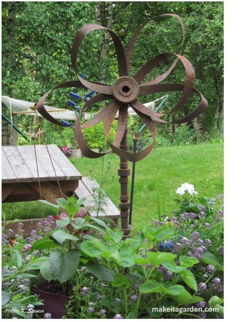 Flower made from rusty farm equipment parts in this display and garden focal point