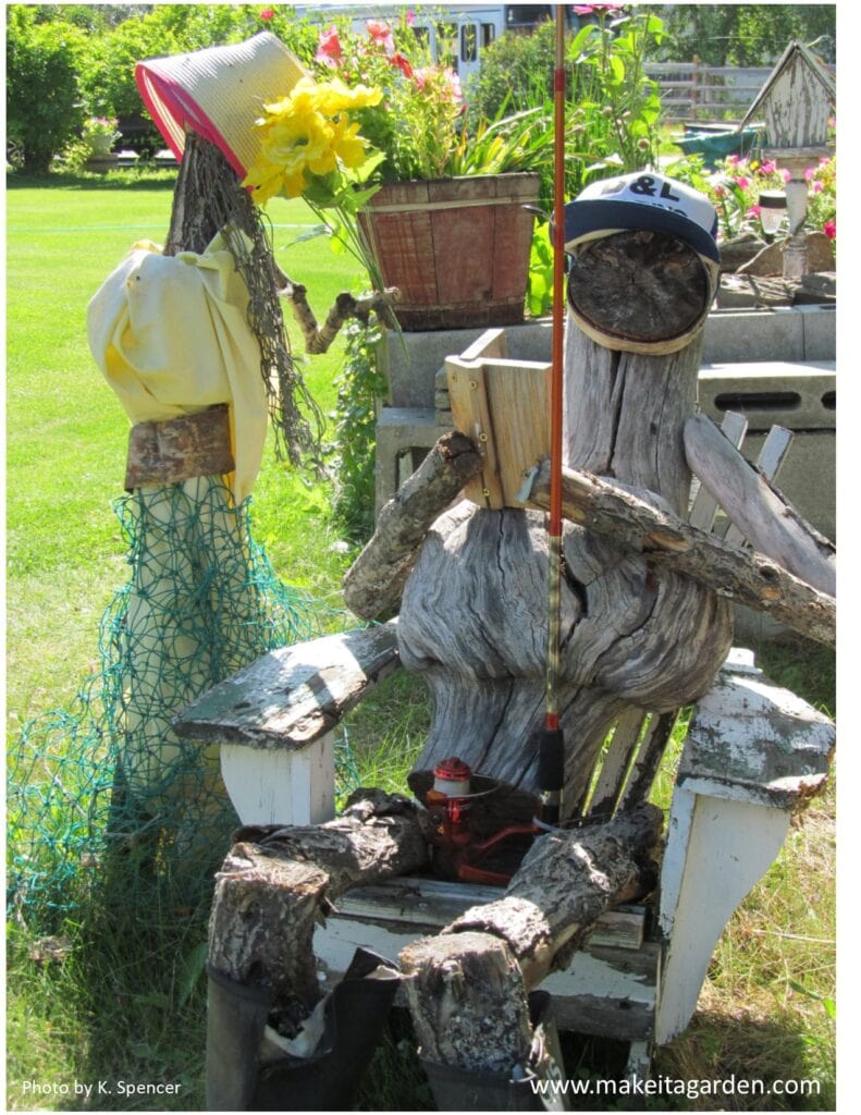 2 characters made from driftwood. Fisherman and wife. Fisherman sitting on chair holding fishing pole. Wife stands next to him with netting for a skirt. 