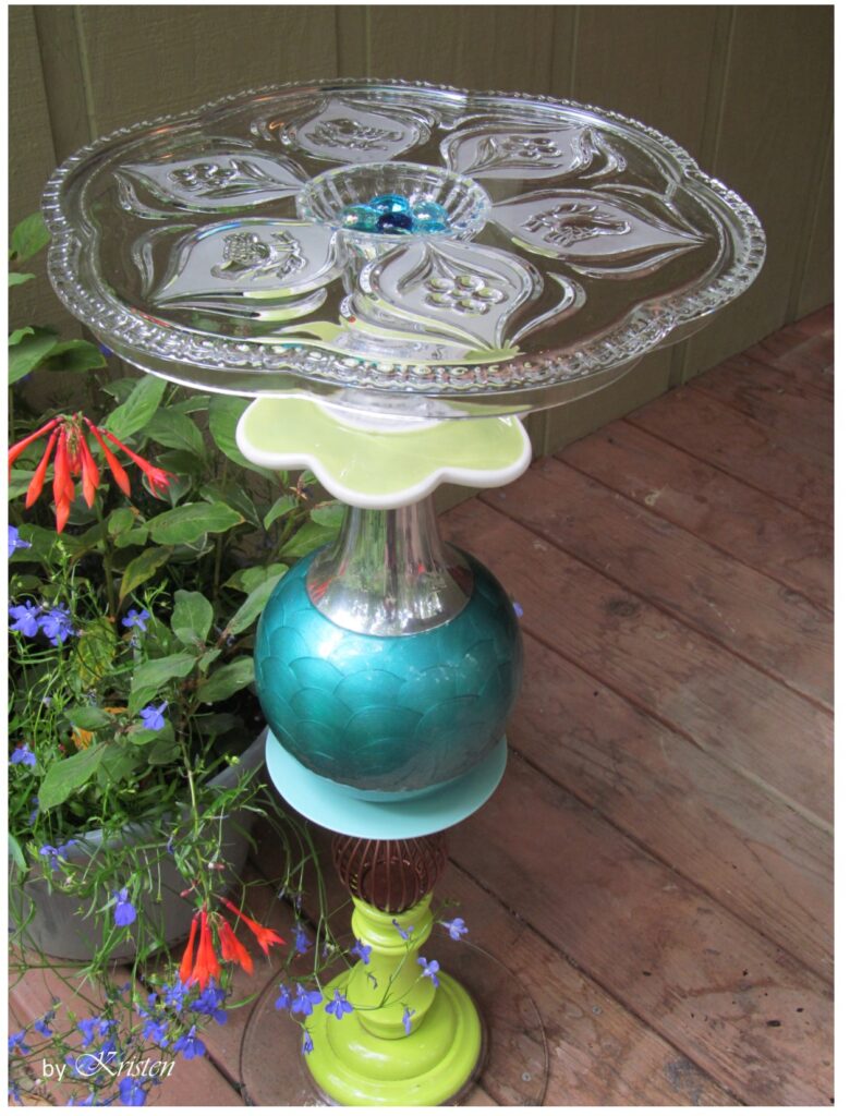a whimsical patio table make with plates and a vase. Demonstrates a problem for glue and glass garden art