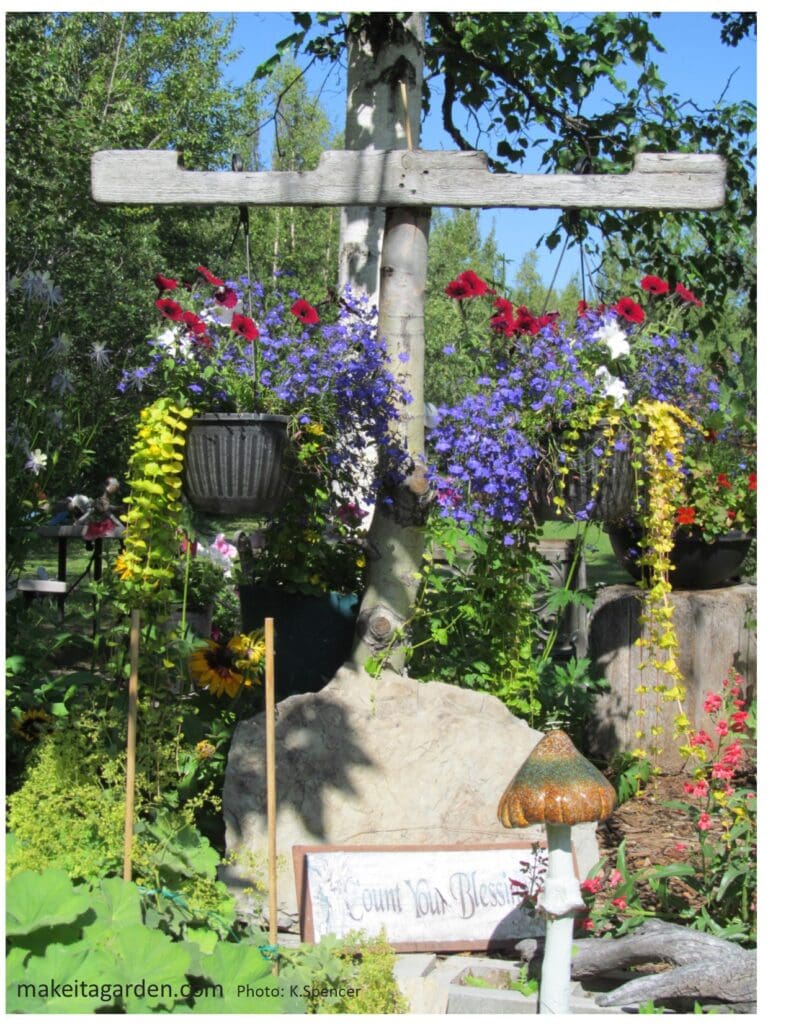 dazzling flower garden. Two large baskets of flowers hang from a wooden cross-beam in the garden next to a tree