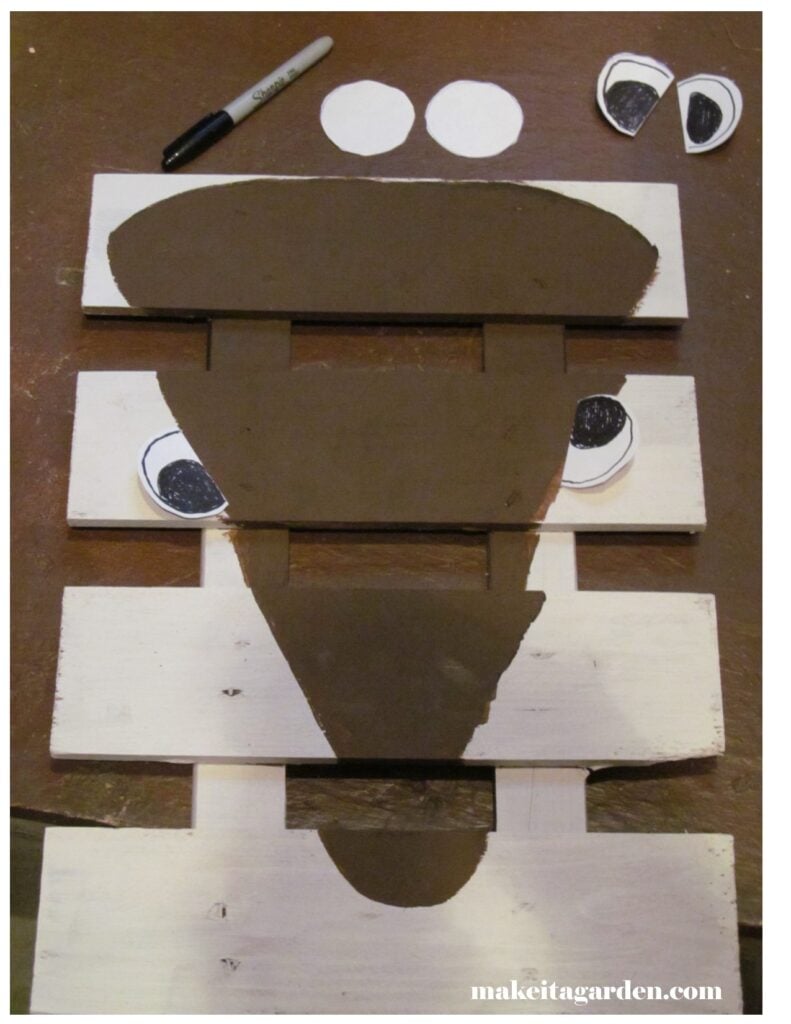Use the paper "eye" circles to try different face expressions for the wood pallet reindeer