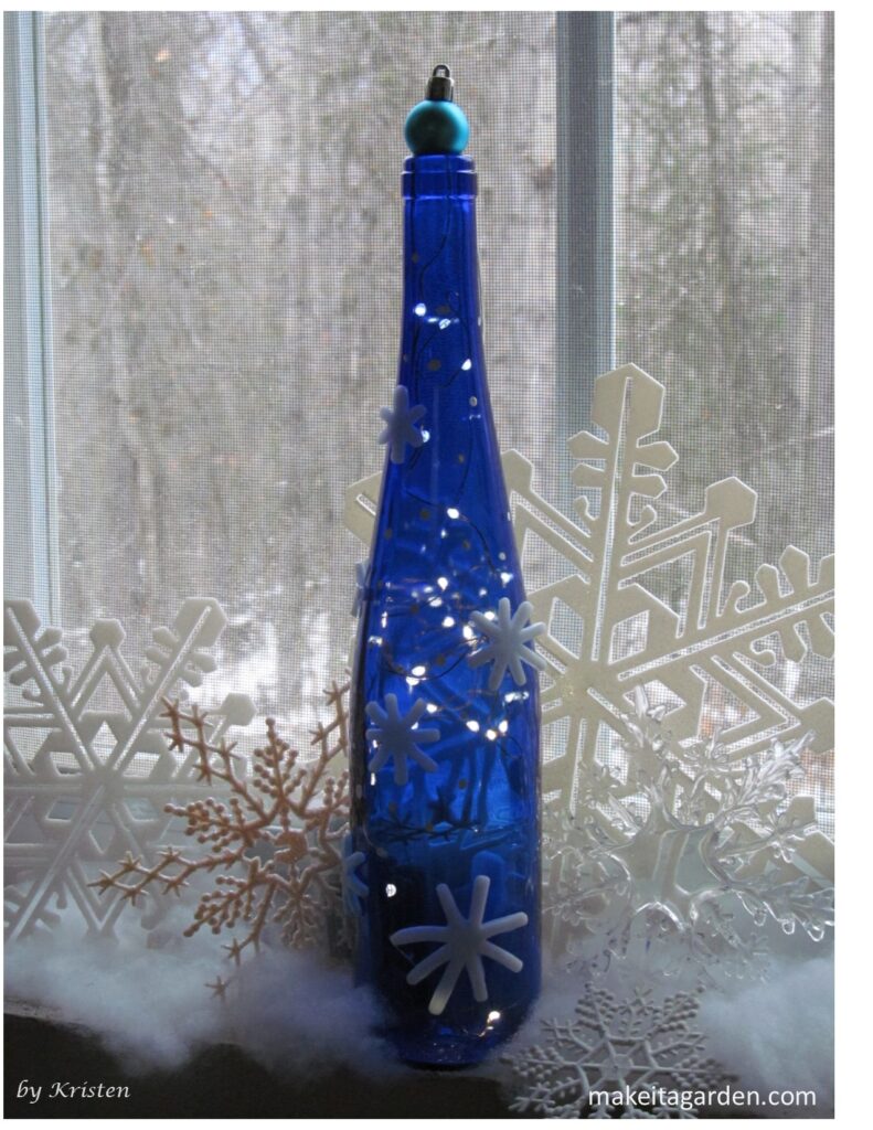 Blue wine bottle glass with mini lights on the inside that make it sparkle.