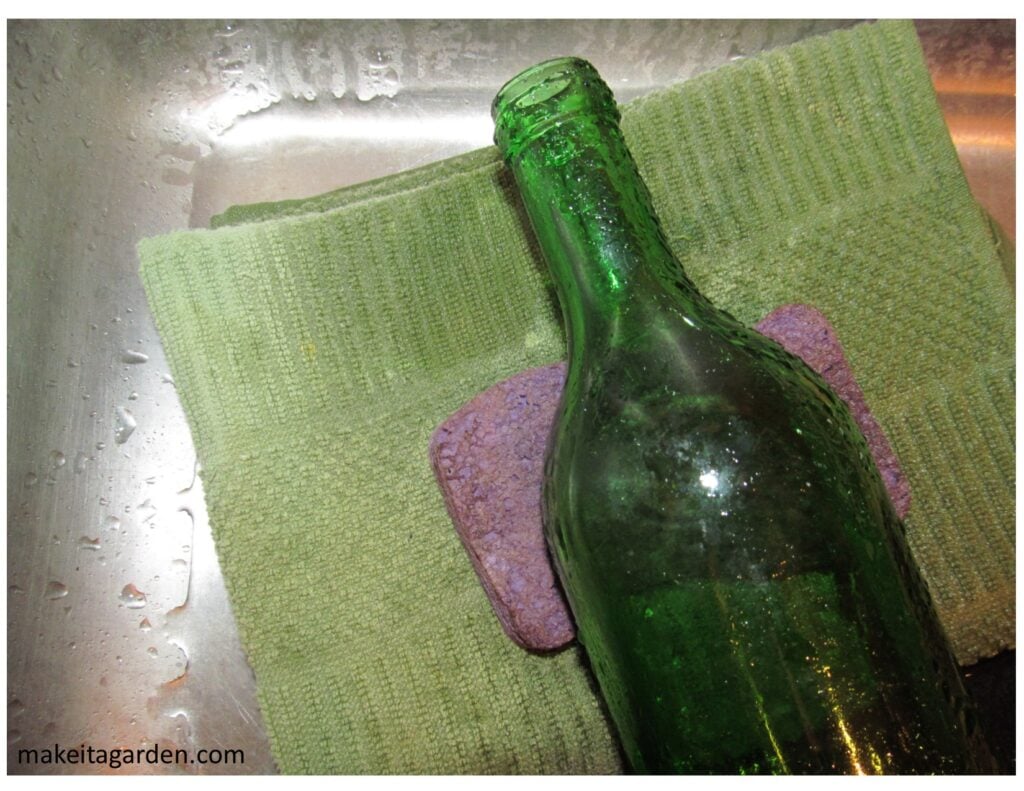Bottle is laid down in bottom of sink with a towel and sponge underneath to help keep it from moving around while being drilled