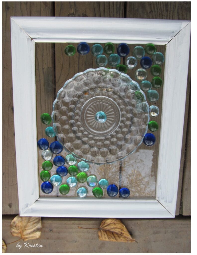 Photo of the art piece. Small decorative glass dish and colored glass beads are glued to the glass pane of a photo frame. Picture Frame Glass Art