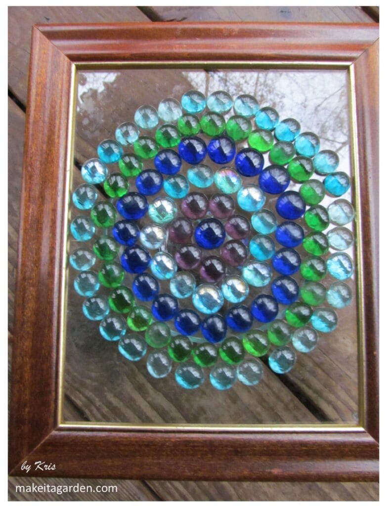 Example 2 of a glass bead artwork glued to surface of glass in a circle pattern.