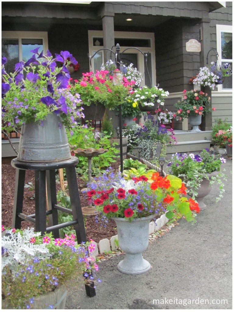 multitude of baskets and planters at various heights line the walkway to a front door