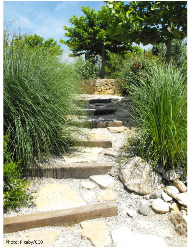 garden pathway on a hill made with stone stair steps is a garden path ideas. 