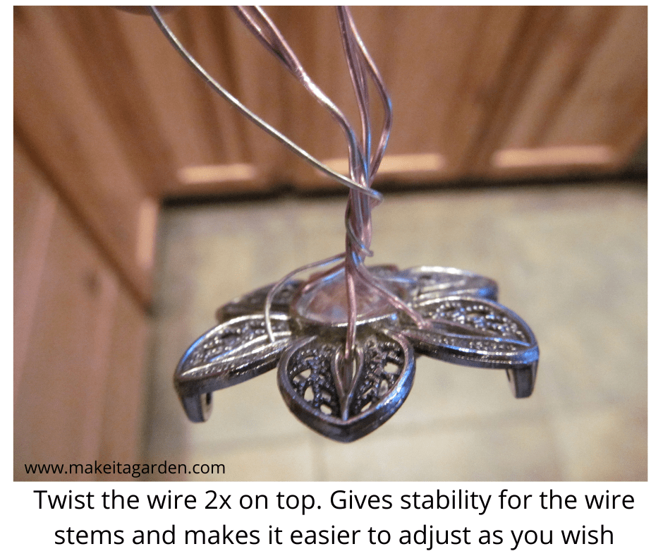 Shows the wires put thru the slits in the jewelry piece for making the center stamen of the garden art flower