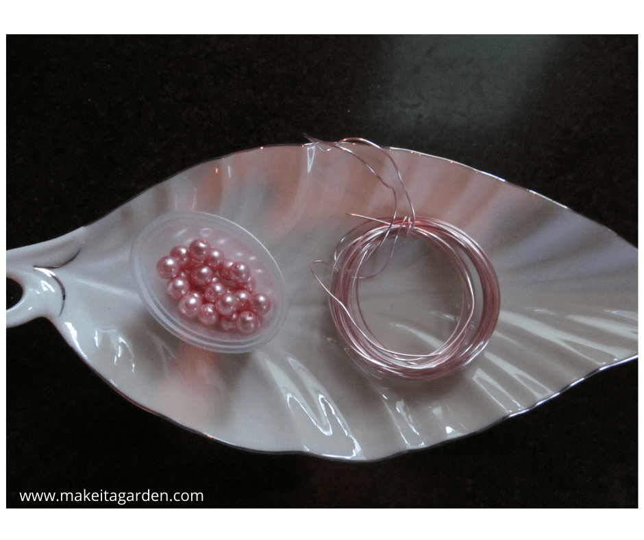 Jewelry beads and wire used for making a stamen centerpiece on a garden art flower