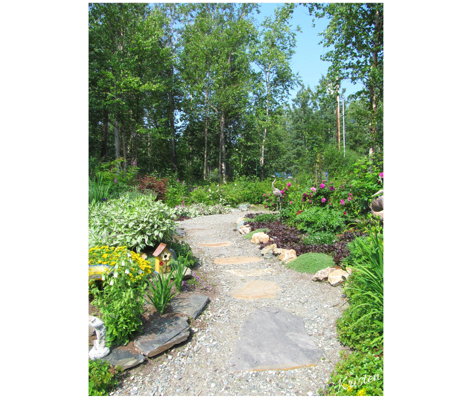 garden path ideas a gravel and natural stone pathway curves through a beautiful flower garden with flowers on either side of path.