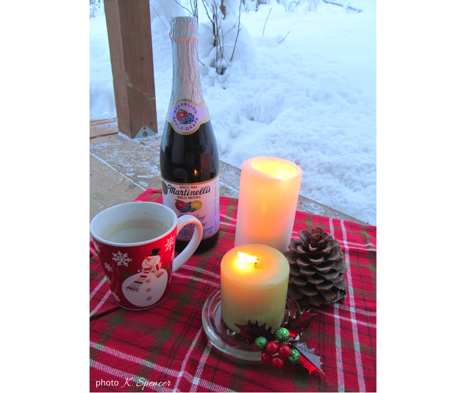 bottle of wine, mug, and some candles outside on the deck in winter. Relaxation is a form of the joy of contentment.