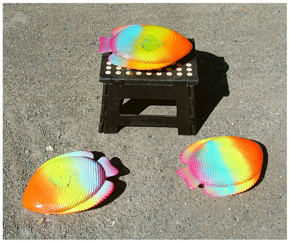 thrifty yard art plastic fish plates spray painted drying in the sun