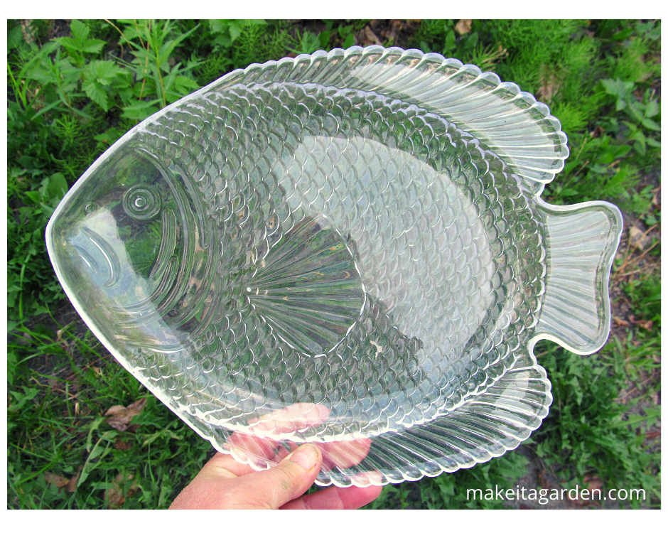 thrifty yard art. a clear plastic fish shaped plate from the thrift store