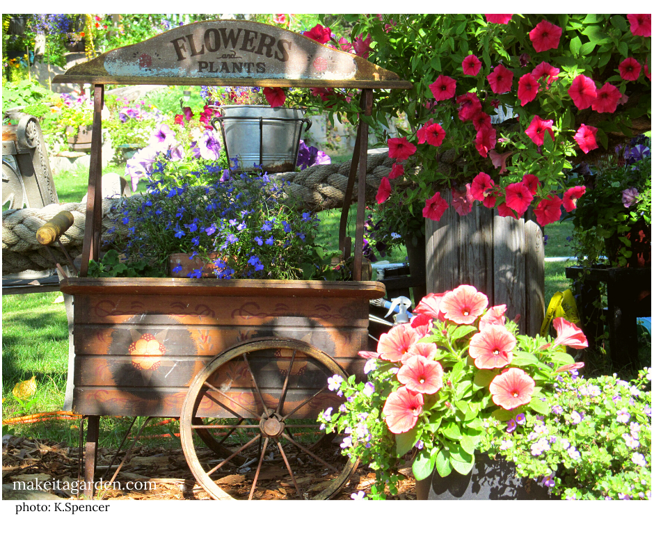 Baskets and planters of flowers fill a wooden garden cart