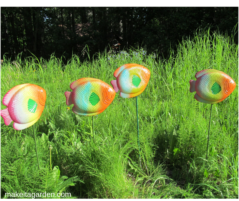 bright colored plastic school of fish swim thru grass spray paint garden art
