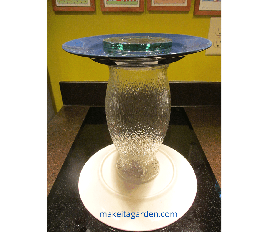 clear glass vase glued between two plates provides the base of the fountain